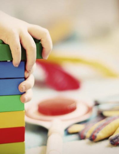 A stock photo of toddlers eating fruit and having a chat in the playroom.